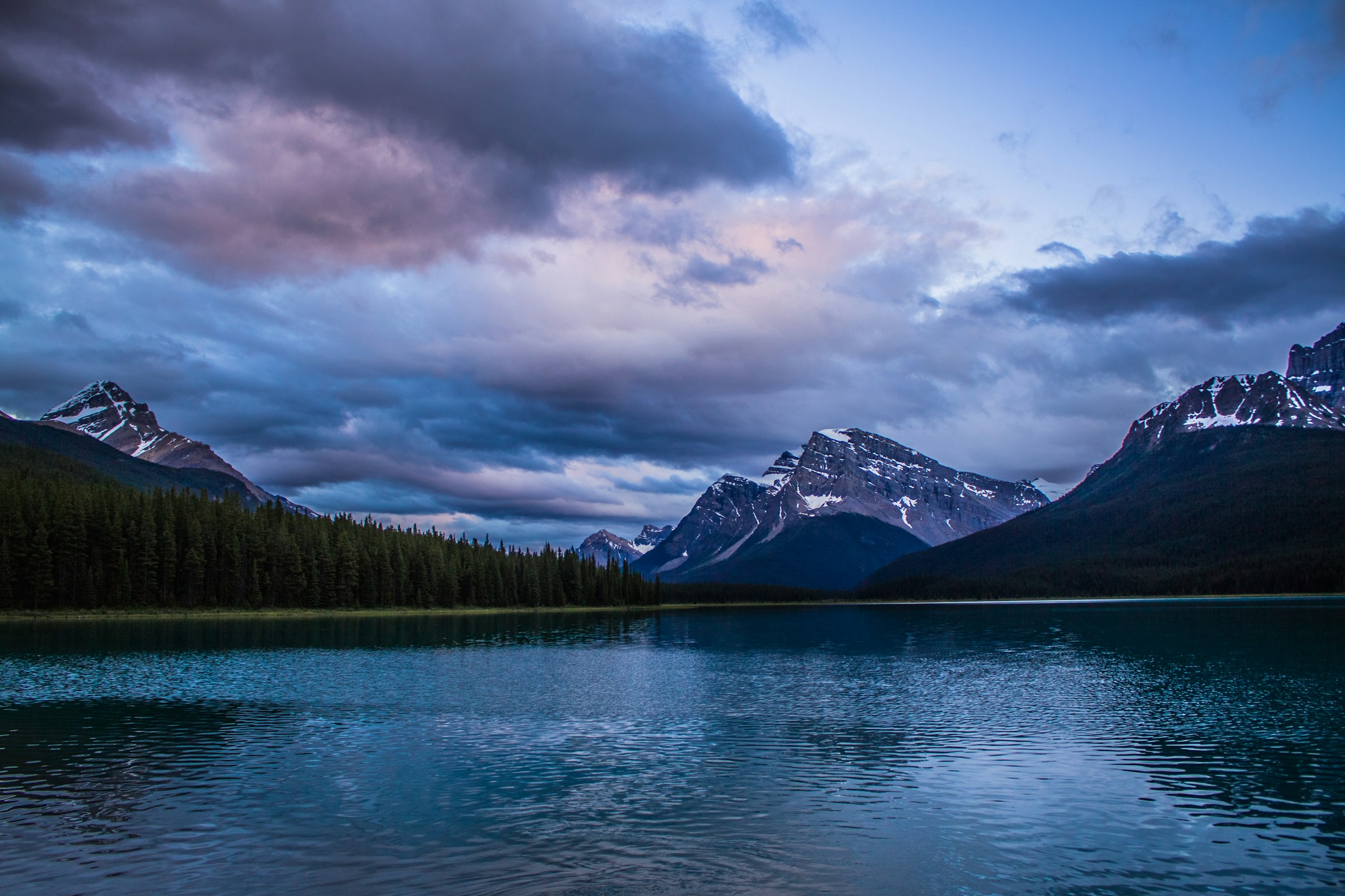 Snowy mountains, forest, and an alpine lake